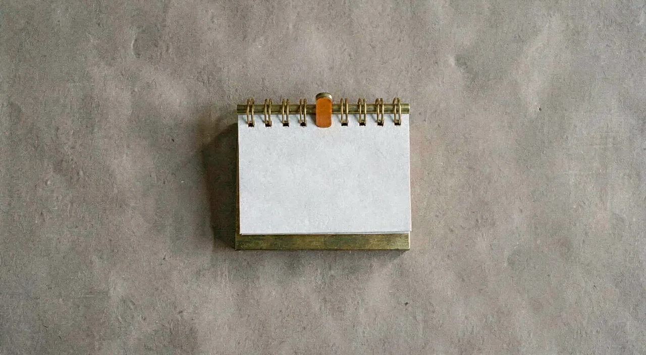 A small brass desk calendar stand, shot from above